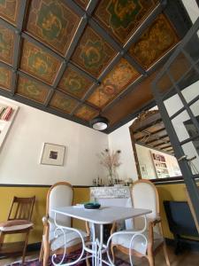 een tafel en stoelen in een kamer met een plafond bij Villa Centre ville et plage Le Mascaret in Villers-sur-Mer