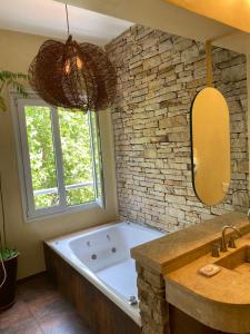 a bathroom with a large tub and a stone wall at Rendez Vous Hotel Buenos Aires in Buenos Aires