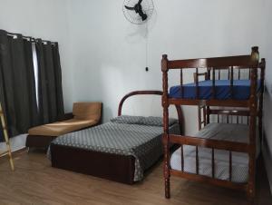 - une chambre avec des lits superposés et une chaise dans l'établissement Suites Coqueiros Itamambuca, à Ubatuba