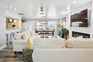 a living room with white couches and a kitchen at Royal Blue Dreams flexible rental near Anna Maria Island in Bradenton