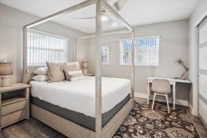 a bedroom with a canopy bed and a desk at Royal Blue Dreams flexible rental near Anna Maria Island in Bradenton +25 photos