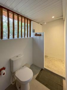 a bathroom with a toilet and a window at OLITAS - Praia de algodões in Marau