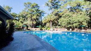 uma grande piscina com água azul e árvores em 3414 Carolina Place em Hilton Head Island