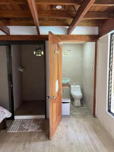 eine offene Tür zu einem Bad mit WC in der Unterkunft Hotel Liah's in Tortuguero