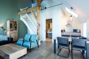 a living room with blue chairs and a table at Boerderijkamer de Delle in Wijhe