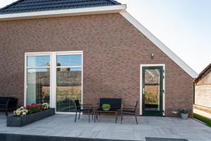 Wijhe的住宿－Boerderijkamer de Delle，砖砌建筑前带桌椅的庭院