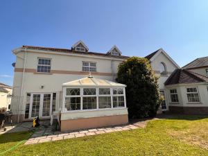 a large white house with a conservatory in the yard at A beautiful Large 7 bed house in Porthcawl
