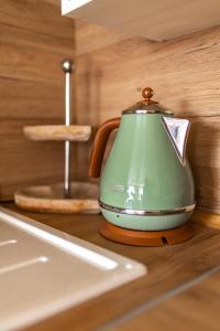 a green tea kettle sitting on top of a counter at Happy Town Apartments in Veliko Tŭrnovo