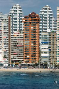 ベニドルムにあるApartamentos Torre Don Vicente - Arca Rentの高層ビルと人々が集まるビーチ