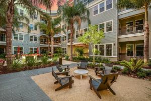 un patio con sillas y una mesa frente a un edificio en Grady Square 1 Bedroom en Tampa