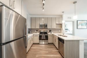 a kitchen with white cabinets and a stainless steel refrigerator at Grady Square 1 Bedroom in Tampa