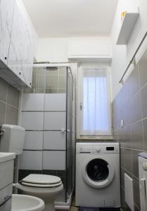 een badkamer met een toilet en een wasmachine bij Renesmee Beach Apartment in Pietra Ligure