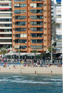 un grupo de personas en una playa con un edificio alto en Apartamentos Torre Don Vicente - Arca Rent, en Benidorm