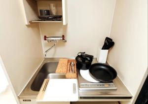 a kitchen with a sink and a pan on a stove at ＰＩＡＺＺＡーＵ - Vacation STAY 77958v in Tokyo