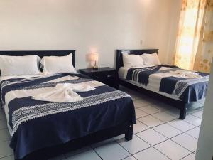 a bedroom with two beds with blue and white sheets at HOTEL MILIN in Villa Comaltitlán +13 photos