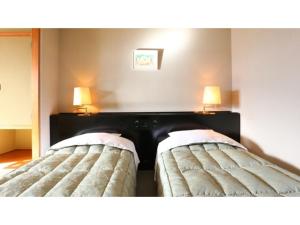 two beds in a room with two lamps on the wall at Hotel Silk in Madarao - Vacation STAY 79648v in Iiyama +45 photos