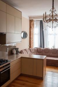 a kitchen and a living room with a couch at Apartament Kwiatowa in Poznań