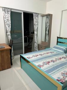 a bedroom with a bed and a table and a window at Little nest Homestay in Pune