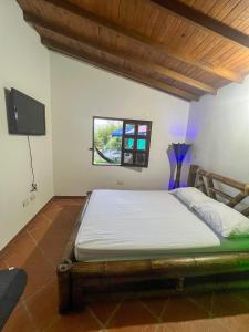 a bedroom with a bed and a tv in a room at Finca Palma de Coco, Municipio de el Peñol Antioquia in El Peñol +33 photos