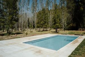 una piscina en un patio con árboles en el fondo en Finca Pequeña Venecia, en San Rafael