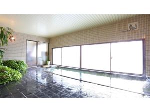 Hotel Silk in Madarao - Vacation STAY 79652v في Iiyama: حمام سباحة في غرفة مع نوافذ زجاجية