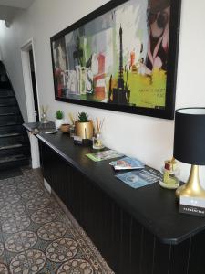 un comptoir noir dans une pièce avec une photo sur le mur dans l'établissement Suites Clémenceau, au Havre
