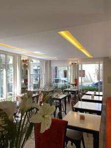 restauracja ze stołami, krzesłami i oknami w obiekcie Rendez Vous Hotel Buenos Aires w BuenosAires