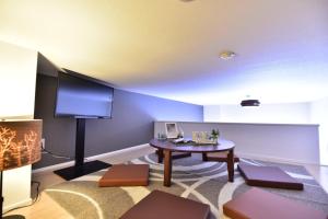 a living room with a table and a flat screen tv at Monotone Nanba - Vacation STAY 15469 in Osaka