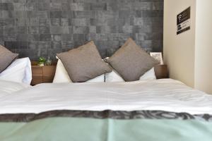 a bedroom with a bed with white sheets and pillows at Monotone Nanba - Vacation STAY 15469 in Osaka