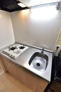 a kitchen counter with a stove and a sink at Monotone Nanba - Vacation STAY 15469 in Osaka