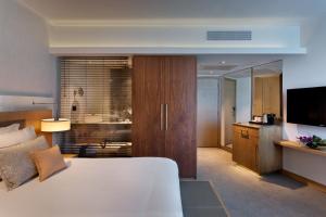 a hotel room with a bed and a dresser at Sea Tower by Isrotel Design in Tel Aviv