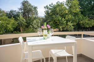 a white table and chairs on a balcony with wine glasses at Palmove Makenzie Studio 4 in Larnaca