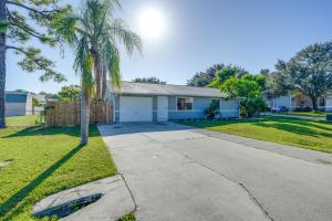 a house with palm trees and a driveway at Fort Myers Vacation Home with Patio about 14 Mi to Beach in Fort Myers