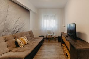 a living room with a couch and a flat screen tv at Augustin Apartment in Arad