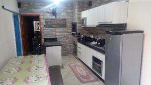 una cucina con elettrodomestici bianchi e un muro di mattoni di Casa Rota das 3 Fronteiras a Foz do Iguaçu