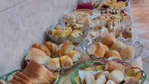 a table topped with lots of different types of bread at Hotel Pousada Recanto da Madá in Aparecida