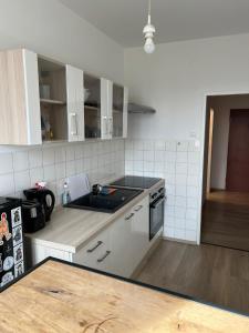 cocina con armarios blancos y fogones en City Appartement 4600, en Wels