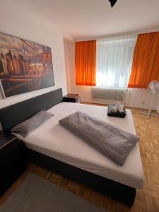 1 Schlafzimmer mit 2 Betten und orangefarbenen Vorhängen in der Unterkunft City Appartement 4600 in Wels