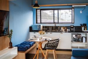 a kitchen with a table and a blue wall at Cabanas Parador do Rei in Urubici