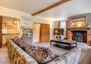 a living room with a couch and a fireplace at The Manor House in Bramfield