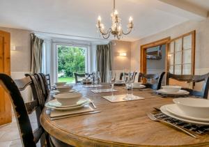 a dining room with a large wooden table with chairs at The Manor House in Bramfield