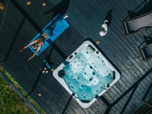 a woman is standing next to a hot tub at Rezydencja Bieszczady - Solina in Solina