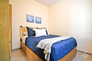 a bedroom with a bed with blue sheets and pillows at NEW Comfy Stay with Pool Onsite Steps from Malecón in La Paz