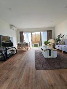 ein Wohnzimmer mit einem Sofa und einem Tisch in der Unterkunft Alice House in Auckland