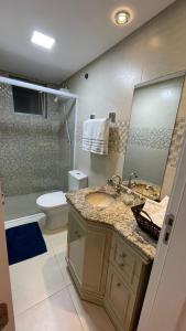 a bathroom with a sink and a toilet and a mirror at Apto climatizado 3 quartos a 3,7km da Vila Germânica in Blumenau