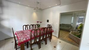 comedor con mesa roja y sillas en Apto climatizado 3 quartos a 3,7km da Vila Germânica en Blumenau