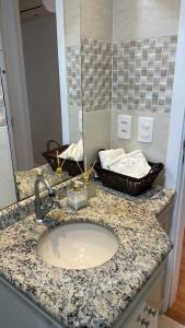 a bathroom counter with a sink and a mirror at Apto climatizado 3 quartos a 3,7km da Vila Germânica in Blumenau