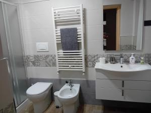 Baño blanco con aseo y lavamanos en Villa Nonno Nicola en Montenero di Bisaccia