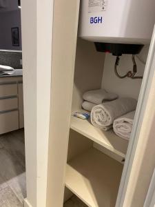 a bathroom with a sink and towels on a shelf at STUDIO BARRACAS in Buenos Aires