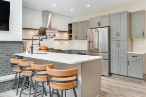 une cuisine avec un grand îlot blanc avec des tabourets de bar dans l'établissement Mid-Century Tenney Mountain Condo Near Hiking, à Plymouth